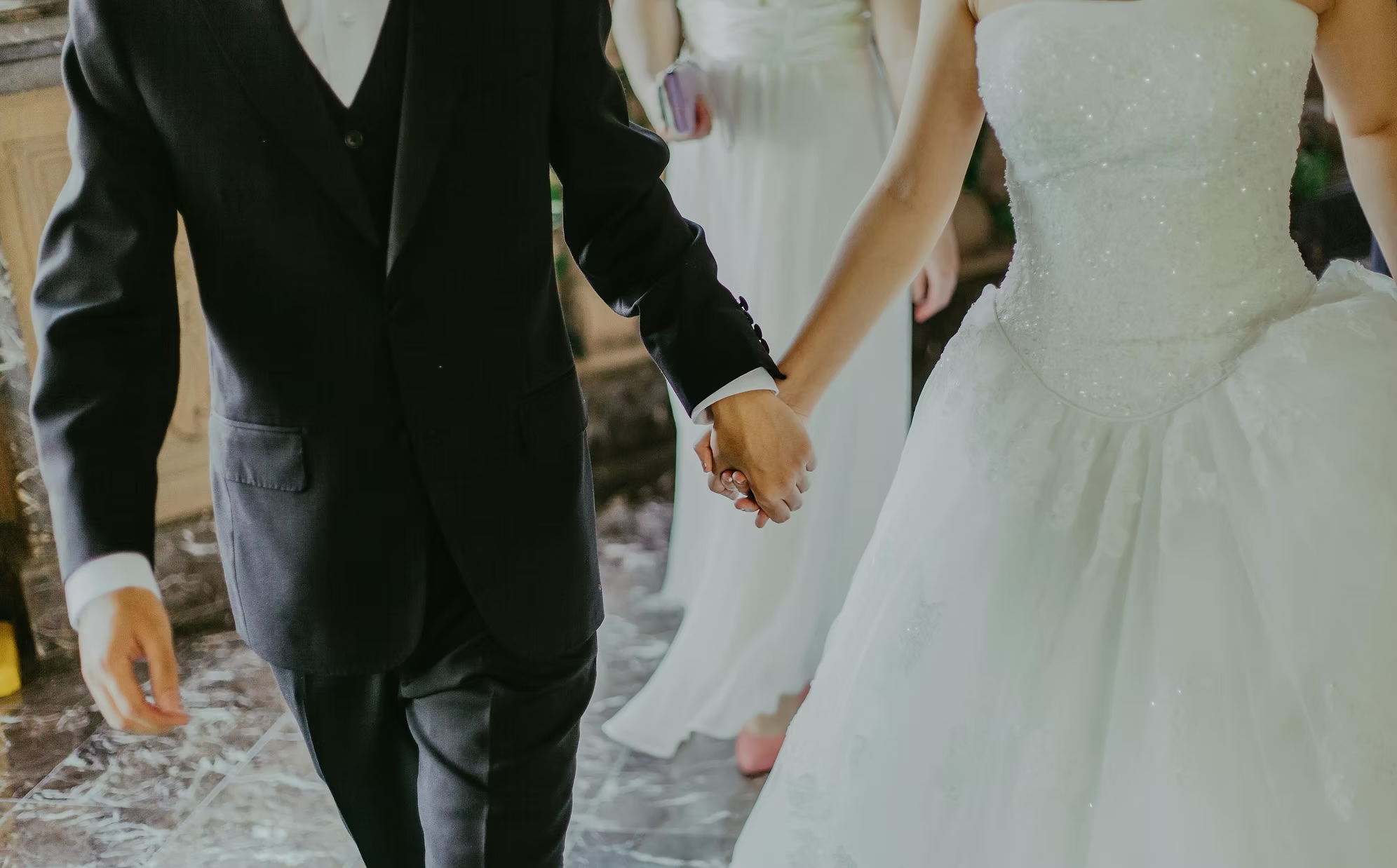 Couple in wedding clothes holding hands